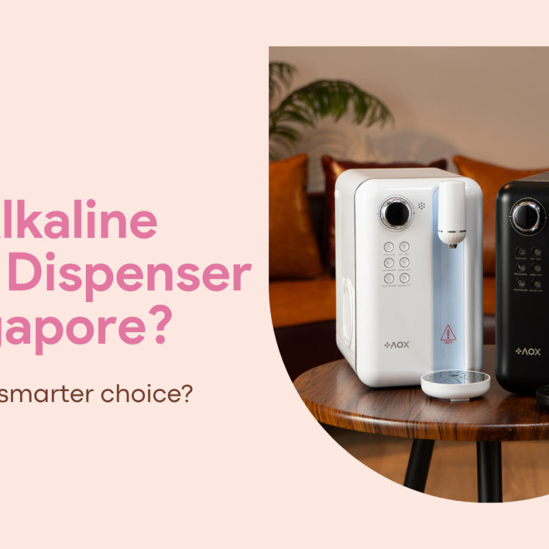 AOX white and black alkaline water dispensers on a wooden table in a modern Singapore home, showcasing a healthier alternative to traditional systems.